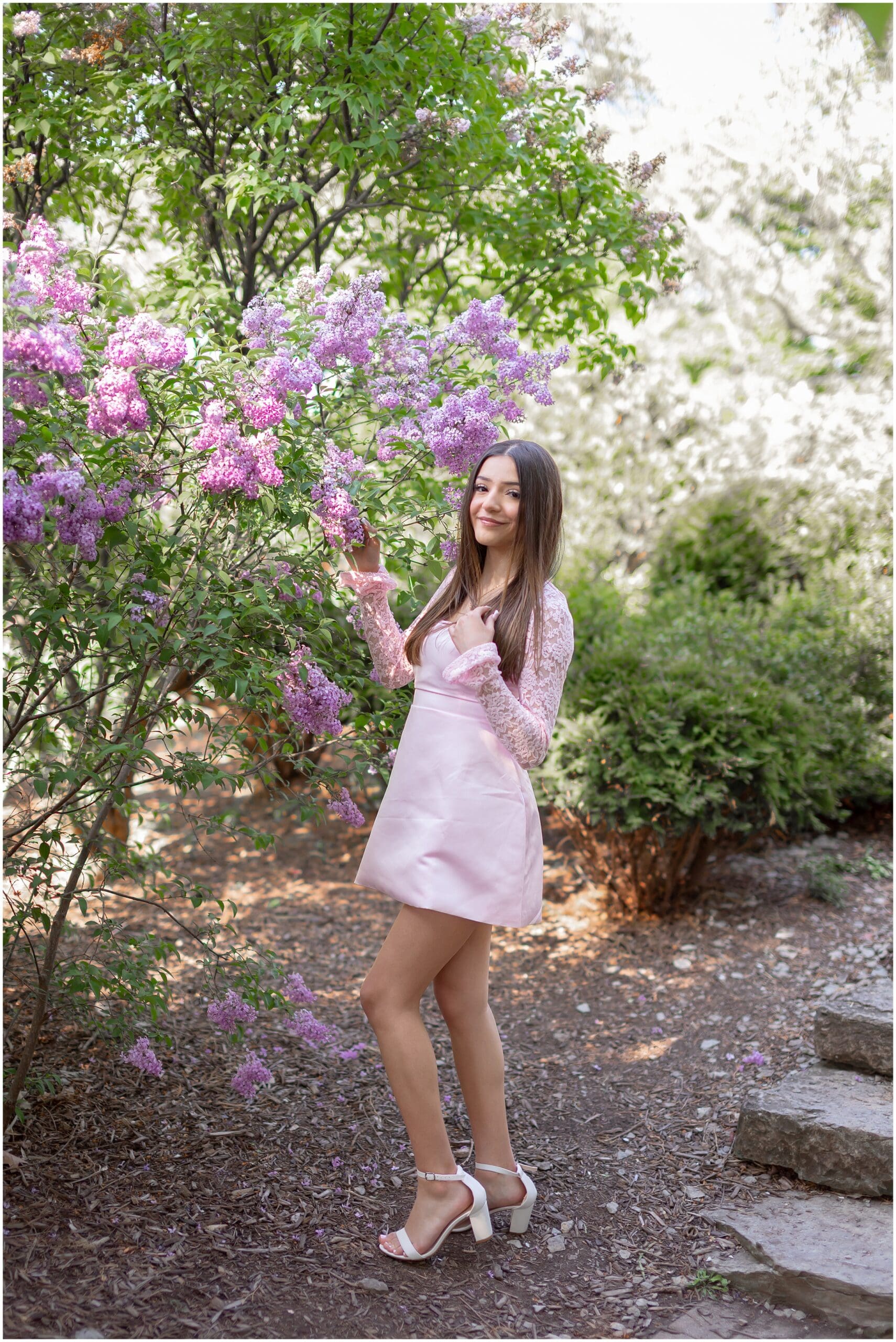 High school senior portrait with vibrant spring flower beds at Lilacia Park in Lombard Illinois