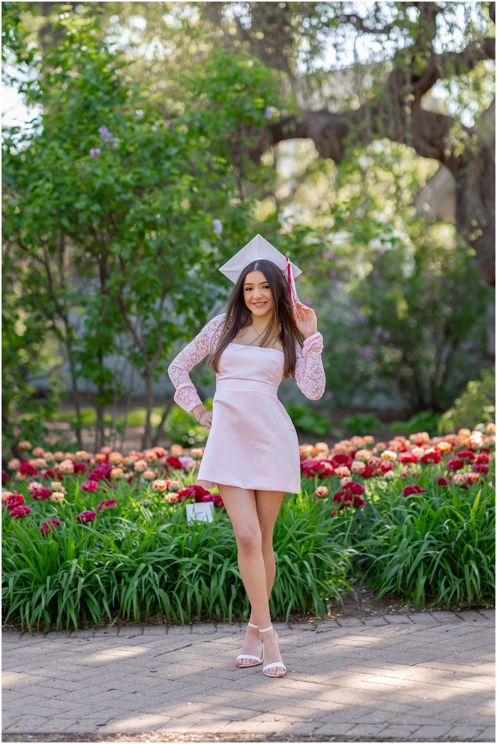 Adorable senior in her cap and gown photo during spring portrait session at Lilacia Park Lombard Illinois